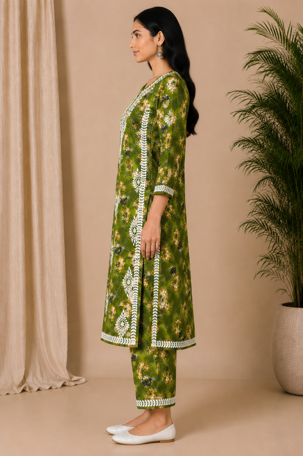 Woman wearing a green floral kurta with white embroidery against a beige background