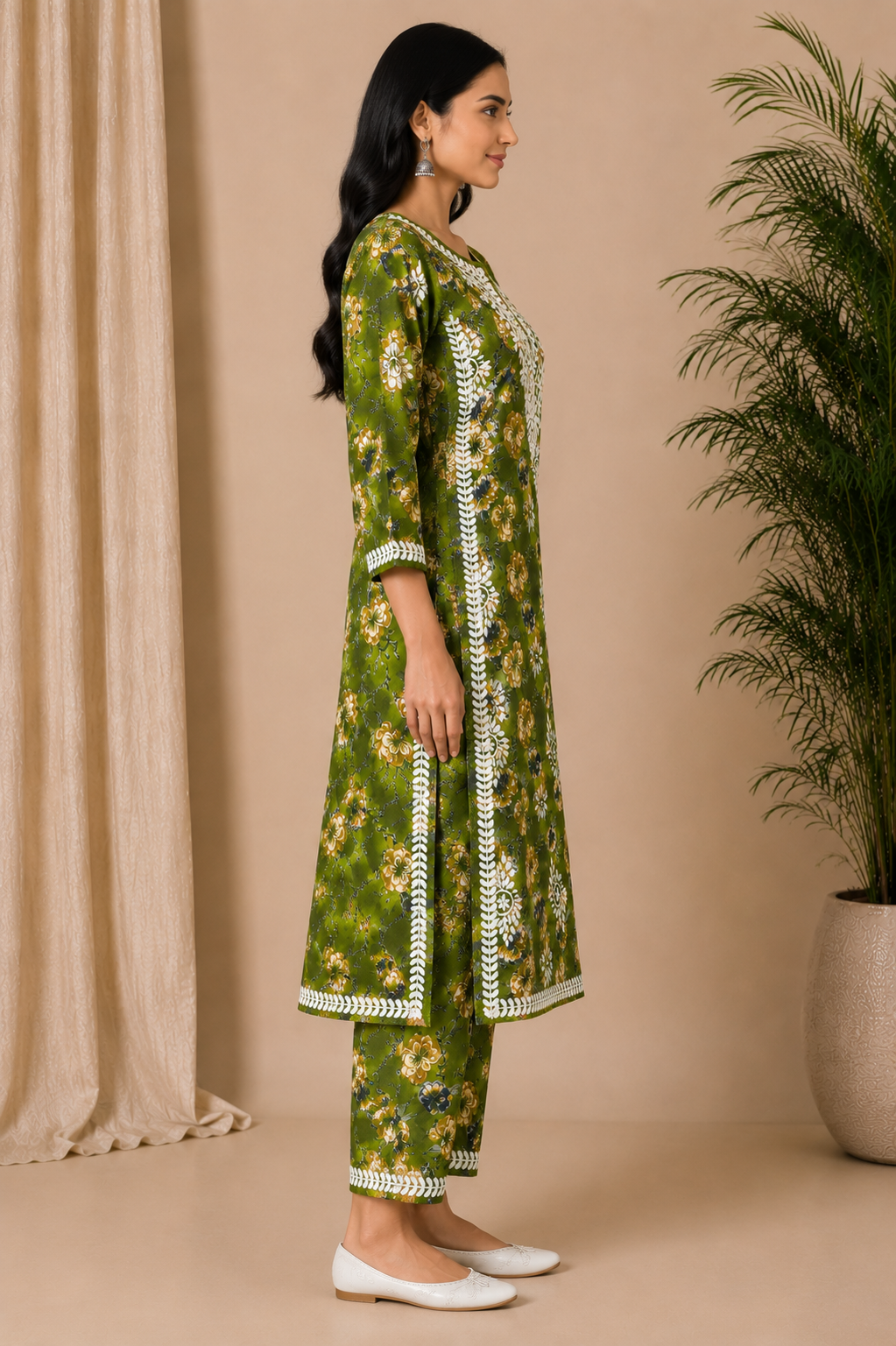 Woman wearing a green floral kurta with white embroidery in a minimalistic setting.